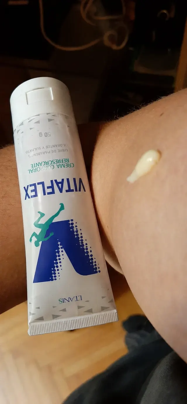 Tubo de Vitaflex junto a una pequeña cantidad de crema sobre la piel